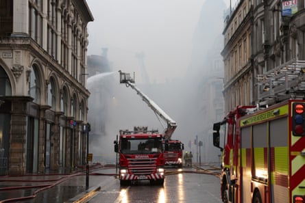 Firefighters damp down the remains of the fire next to Glasgow Central station