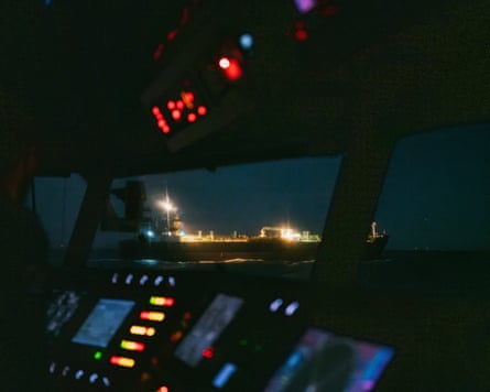 View of a lit-up ship through the window of another ship