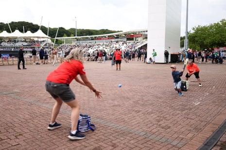 Fans play cricket on a concourse as rain delays the start of the ICC Women's T20 World Cup Group B match between England and Ireland.