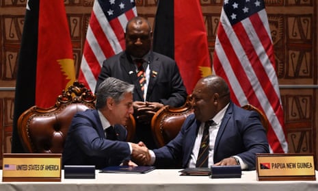 US secretary of state, Antony Blinken (L), and Papua New Guinea defence minister, Win Bakri Daki, shake hands after signing the security agreement, as the prime minister, James Marape, looks on.