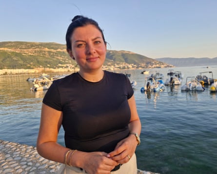 Woman by a bay with inflatable boats moored behind her