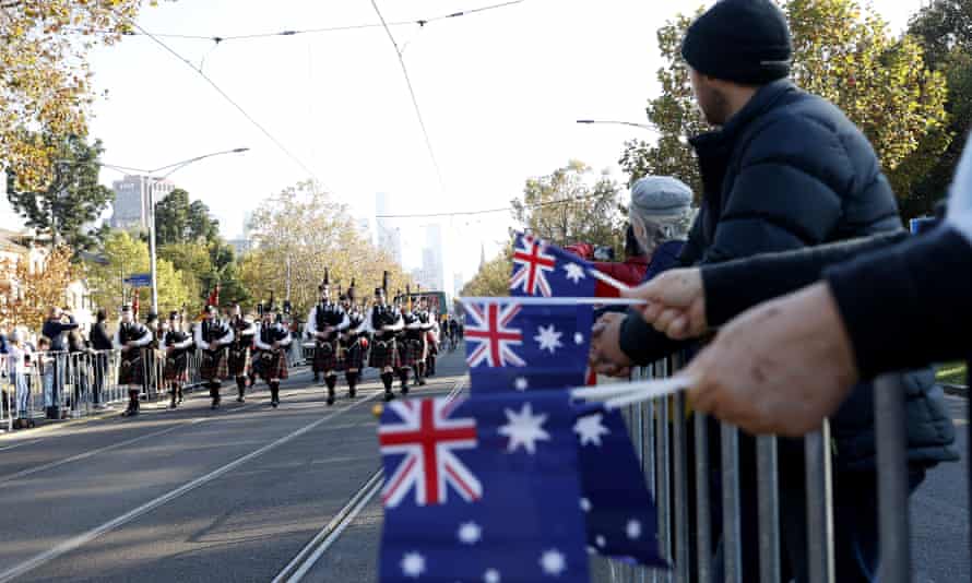 Australian flags are seen as people are seen in the march parade during Anzac Day in Melbourne, Monday, April 25, 2022. T (AAP Image/Con Chronis)
