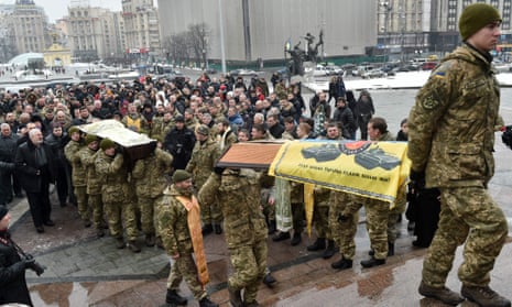 A coffin containing the body of an Ukrainian serviceman who died during fighting in eastern Ukraine is carried in Independence Square, Kiev.