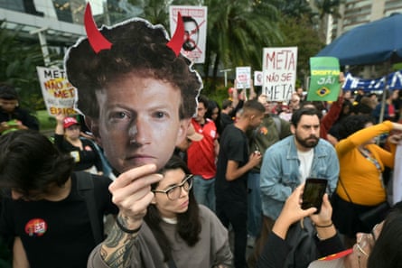 Woman holds up mask of Meta chief executive Mark Zuckerberg outside Meta headquarters.