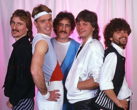 Band portrait. Three have moustaches and two are in 80s athleisure wear
