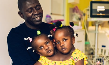 Ibrahima Ndiaye with his conjoined three-year-old daughters Marieme and Ndeye. 