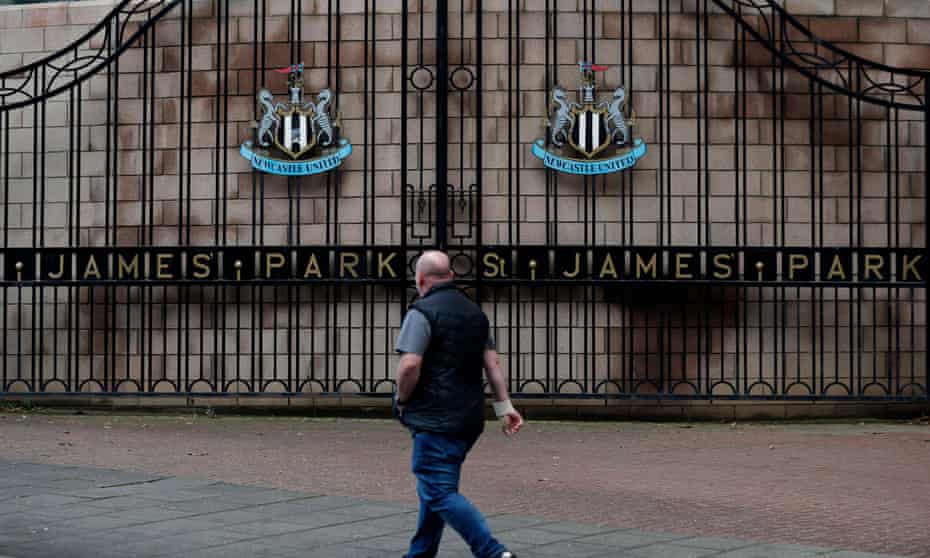 A Newcastle fan walks past the gates of St James’ Park