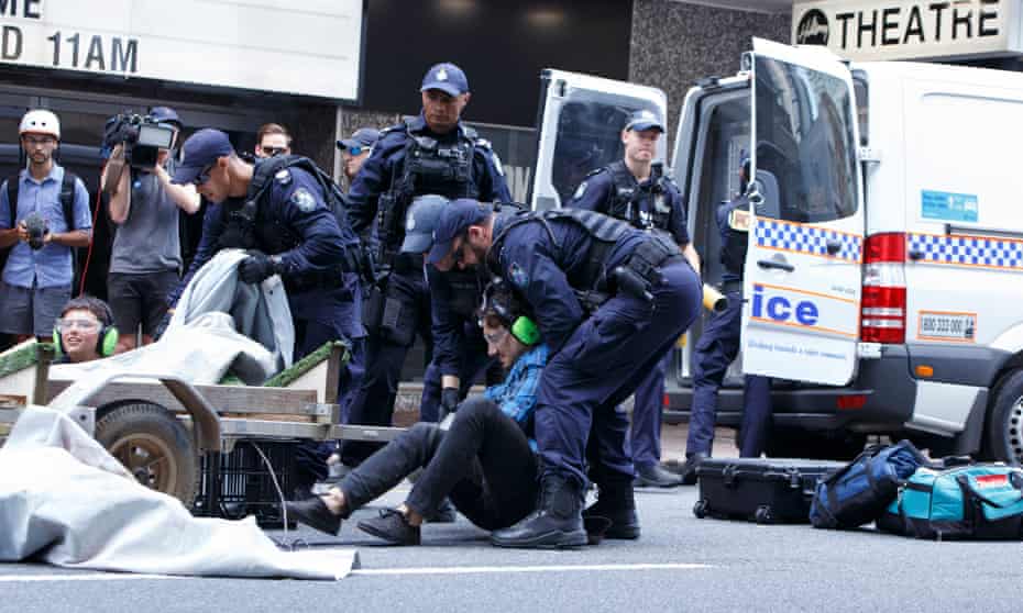 An Extinction Rebellion protester is placed under arrest by Queensland police in Brisbane