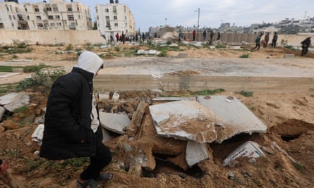 Palestinians look at graves destroyed in an Israeli raid on a cemetery in Khan Younis.