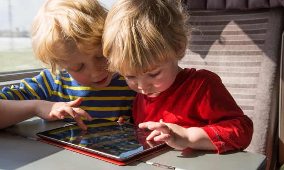 Two young brothers playing on an iPad