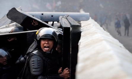 An Indonesian police officer shouts during a clash with protesters outside the parliament building in Jakarta.