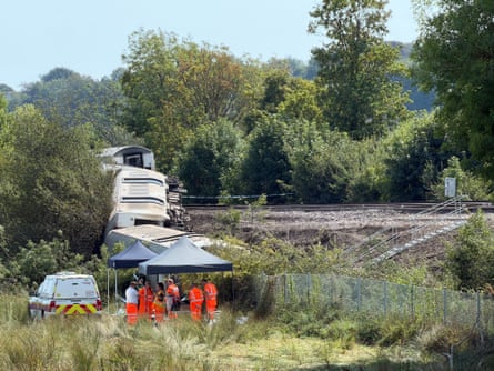 Workers in orange under grey gazebos plan the removal of the carriages in East Sussex.