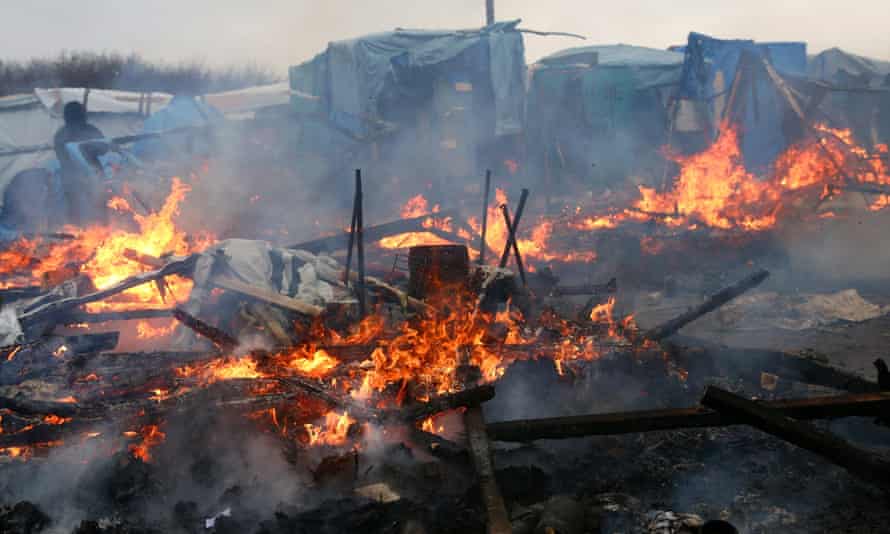A hut burns as part of the ‘Jungle’ camp in Calais is cleared