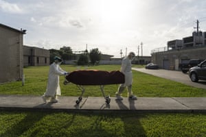 Medical staff wearing full PPE push a stretcher with a deceased patient to a car outside of the Covid-19 intensive care unit at the United Memorial Medical Center on 30 June 2020 in Houston, Texas