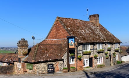 A brick and flint pub against a clear blue sky