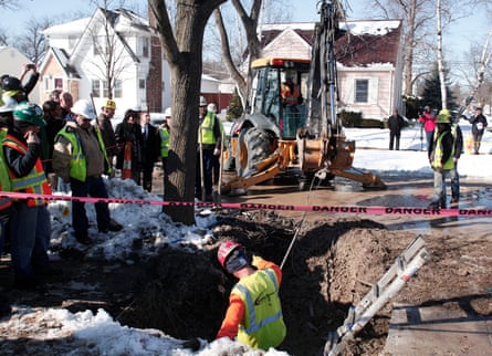 Workers prepare to replace a lead water service line at the site of the first Flint home with high lead levels on 4 March 2016.