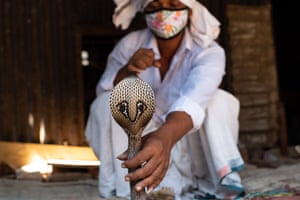 Um homem fazendo uma apresentação cigana tradicional com uma cobra em Dhaka, Bangladesh