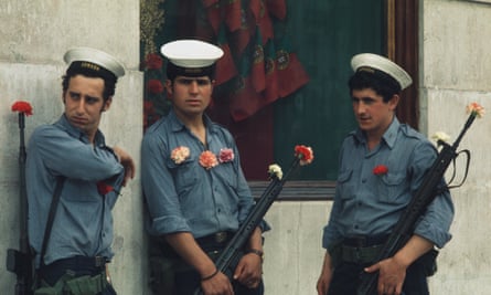 Portuguese soldiers with carnations on their uniforms and in their gun barrels stand guard in Lisbon on 29 April 1974.