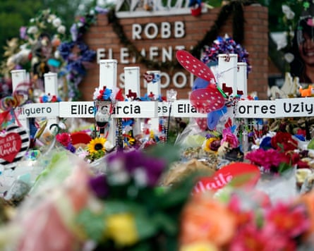 Crosses, flowers and other items near a school sign
