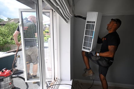 Engineers install an air conditioning unit at a home in the UK