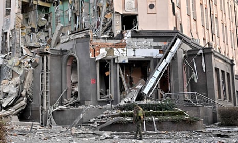 A Ukrainian soldier walks past a Kyiv hotel hit in fresh Russian missile attacks on New Year’s Eve