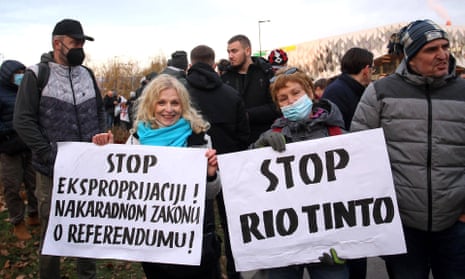 Protesters hold up signs, one in Serbian and one in English saying Stop Rio Tinto