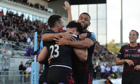 Sean Maitland is mobbed by his teammates after scoring the final try of the game