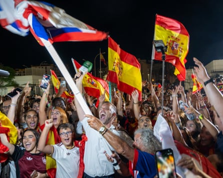 People wave Spanish and British flags as they celebrate the end of border controls between Gibraltar and Spain.