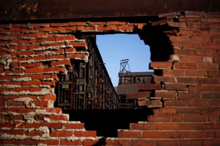 a shuttered steel plant seen through an opening in a brick wall