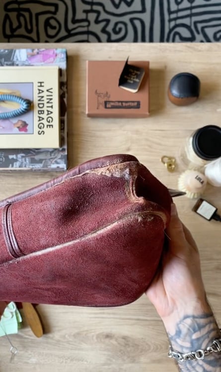 A hand holding a handbag turned inside-out - the easiest way to clean it 