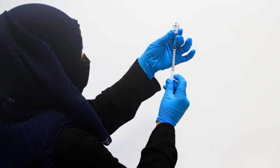A pharmacist fills a syringe with the Pfizer/BioNTech Covid-19 vaccine in Stratford, England. 