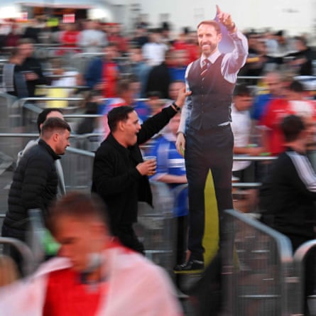 England fans carry a cardboard cut out of England manager Gareth Southgate at the Fan Park in Manchester.
