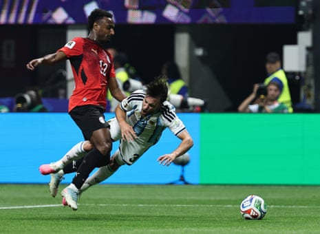 Haissem Hassan of Egypt (left) bundles over Nicolas Tagliafico of Argentina and the referee points to the penalty spot.