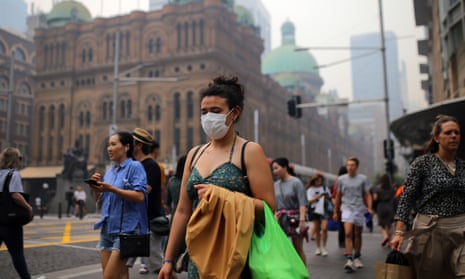 Pedestrians are seen wearing masks as smoke haze from bushfires in New South Wales blankets the CBD in Sydney, Tuesday, December 10, 2019. (AAP Image/Steven Saphore) NO ARCHIVING