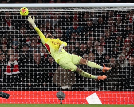 David Raya tips Yankuba Minteh’s shot over the bar to preserve Arsenal’s lead.