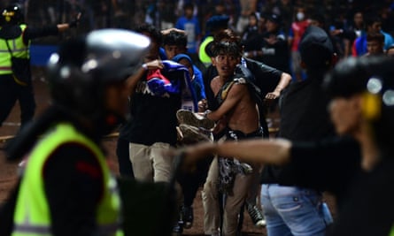 A group of people carry a man in the stadium during the melee