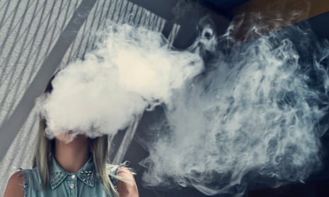 A woman blowing a cloud of vape smoke