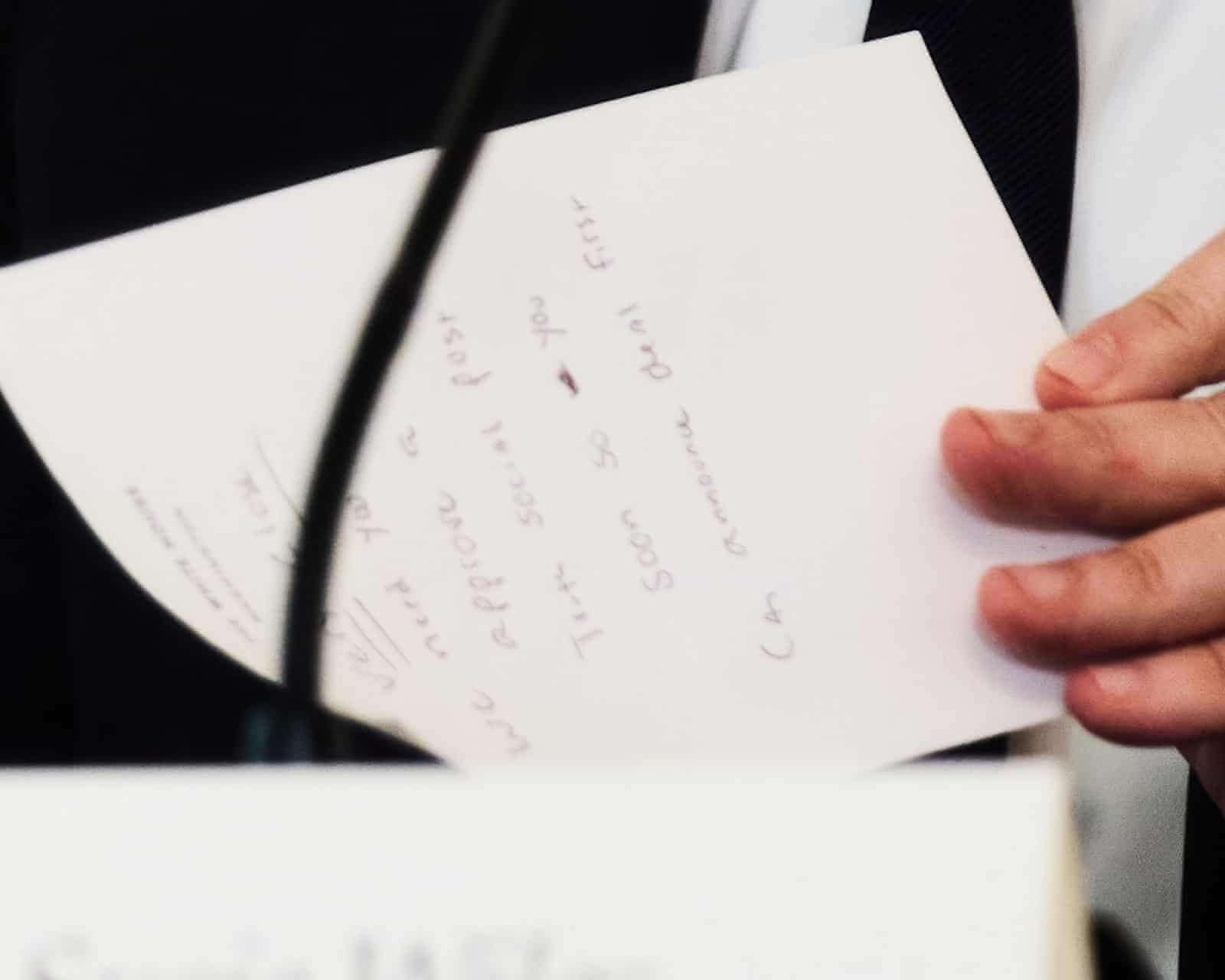 Secretary of State Marco Rubio writes a note before handing it to President Donald Trump during a White House roundtable meeting