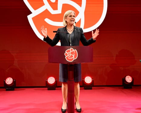 The Social Democrats’ party leader, Magdalena Andersson, standing at a podium decorated with the party's red rose emblem