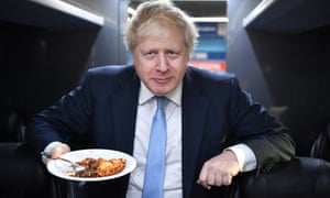 Boris Johnson eats a portion of pie on his campaign bus after a visit to the Red Olive catering company.