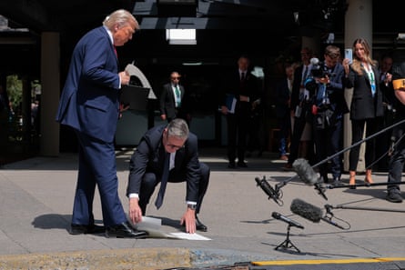 Keir Starmer bends to pick up the signed trade agreement Donald Trump dropped in Kananaskis, Canada.