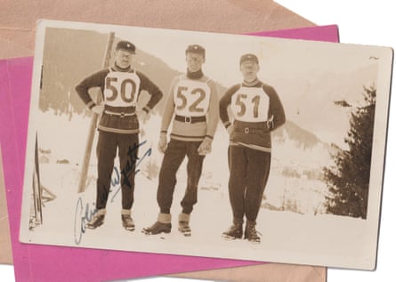 Three skiers wearing numbers on their chests