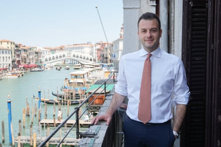 Simone Venturini smiles as he stands on a balcony overlooking Venice’s Grand Canal