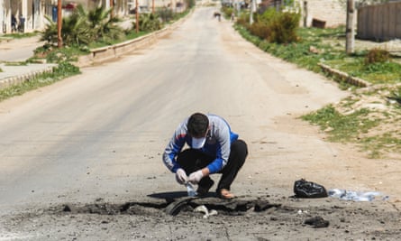 A Syrian man collects samples from the site of a suspected toxic gas attack in Khan Sheikhun in April 2017.