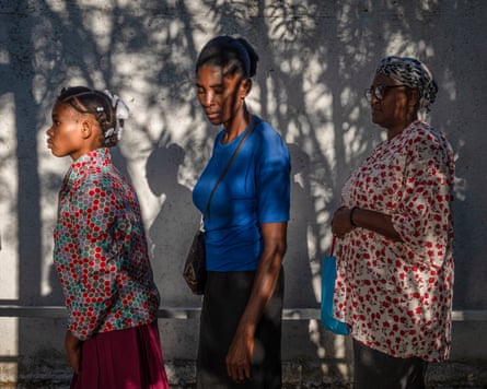 Three women stand facing the same way