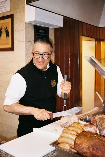 A man cutting cooked ham in a deli