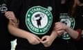 Starbucks workers in black T-shirts link arms