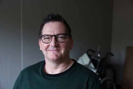 Richard Hewett wearing a dark-coloured T-shirt smiles at the camera