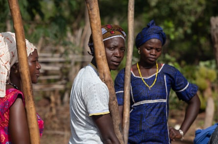 Des femmes pilent le fonio avant de tamiser le grain