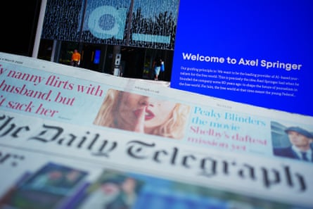 A copy of The Daily Telegraph next to the home page of German media group Axel Springer on a laptop